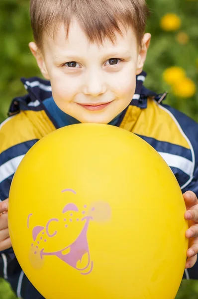 Sonriente niño feliz con globo amarillo — Foto de Stock