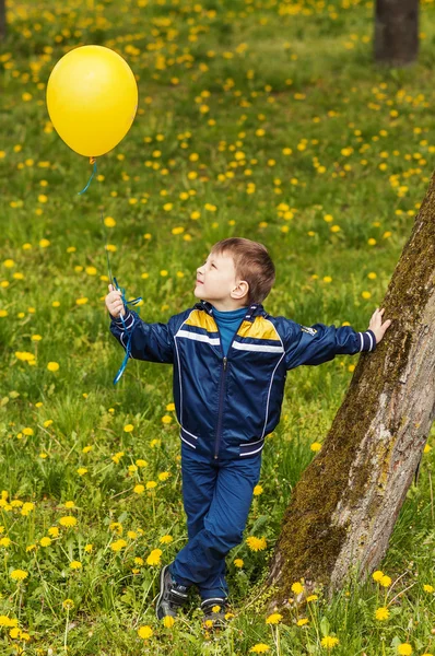 Χαμογελά ευτυχισμένος αγόρι με κίτρινο μπαλόνι — Φωτογραφία Αρχείου