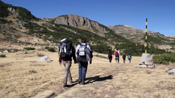 Senderistas caminando por un sendero de montaña — Vídeos de Stock