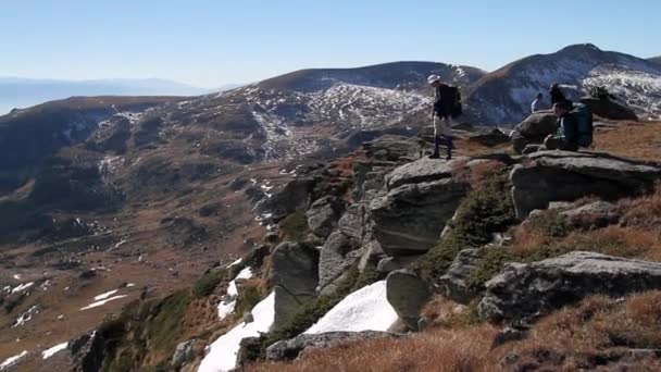 Senderistas con mochila de pie en la cima de una montaña — Vídeos de Stock