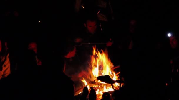 Young adults sitting around a camp fire — Stock Video