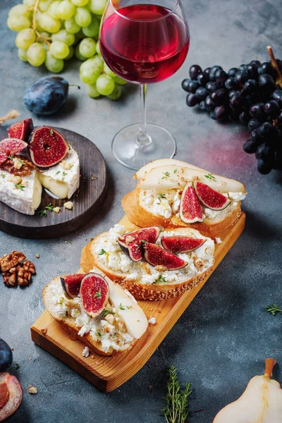 red wine with snacks bruschetta with pears, cottage cheese, figs, thyme, nuts and honey, camembert cheese.