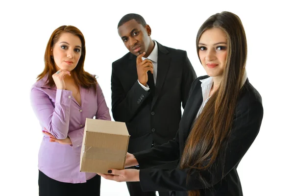 Mujer de negocios sosteniendo una caja frente a sus colegas — Foto de Stock
