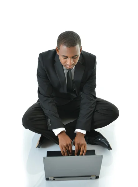 Uomo d'affari digitando sul computer portatile seduto sul pavimento — Foto Stock