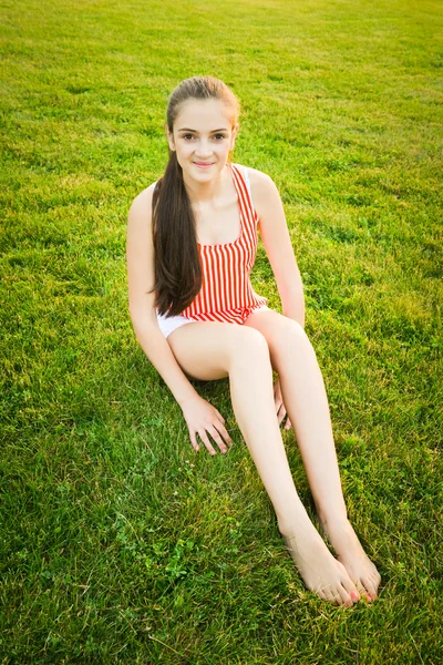 Happy and healthy girl sitting in the park during dusk — Stock Photo, Image