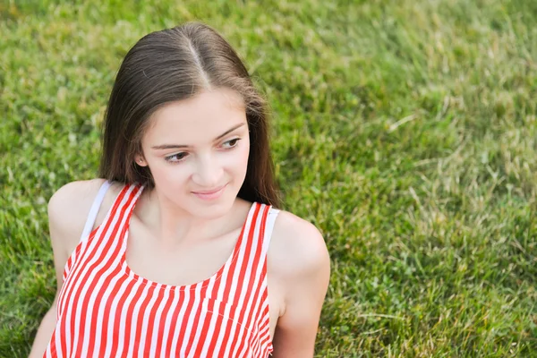 Gelukkige vrouw ontspannen terwijl liggend op gras — Stockfoto