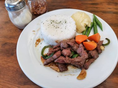 Salpicao bifteği, bir porsiyon pirinç, patates püresi, yeşil fasulye ve havuç. Lezzetli Filipin mutfağı. Orta pişmiş..