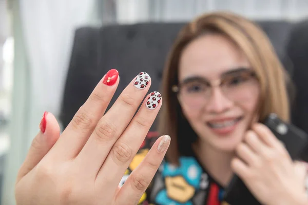 Uma Mulher Asiática Satisfeita Orgulhosamente Mostra Suas Unhas Recém Cuidadas — Fotografia de Stock