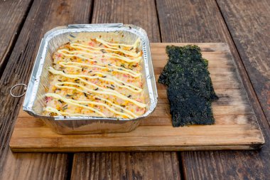 Pişmiş suşi Nori Seaweed ile birlikte ahşap tepside servis edilir. Açık hava restoranı..