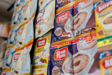 Manila, Filipinler - Jan 2022: Harika Tat ve Kopiko kahve karışımı paketleri bir sari-sari mağazasında sergileniyor.