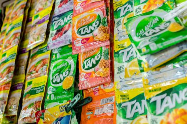 Manila, Filipinler - Ocak 2022: Bir sari-sari mağazasında sergilenen Tang pudra suyu ve Knorr karışık keseleri.