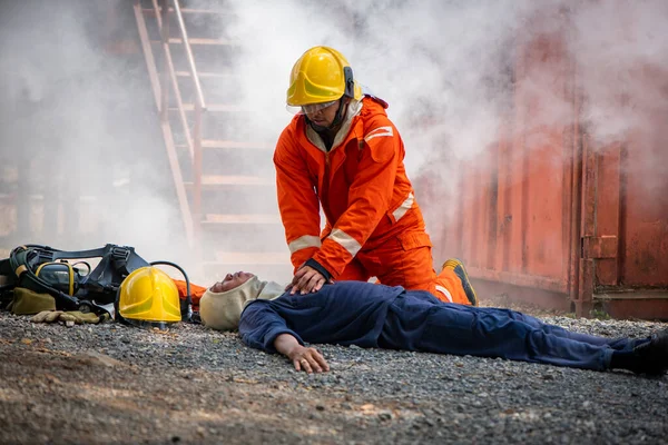 Strażak Garniturze Kasku Ratuje Życie Pompując Serce Ziemię Tłem Dymnym — Zdjęcie stockowe