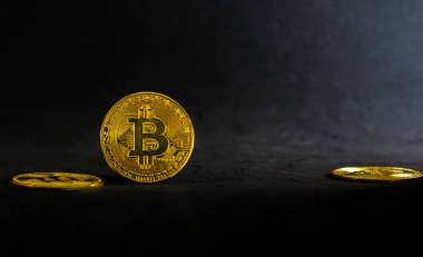 Golden bitcoin, Bitcoin lay on a black table with black background and ray of light.