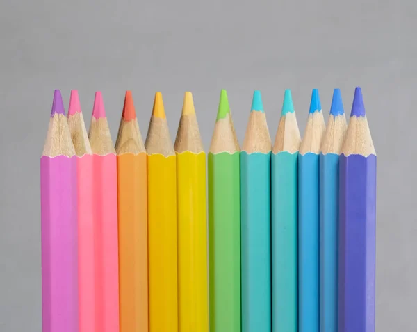 Color pancils, Group of pastel color pencil laying in row striaght line made by pencil tips with grey background close up, Pastel color, Painting equipment, Education concept.
