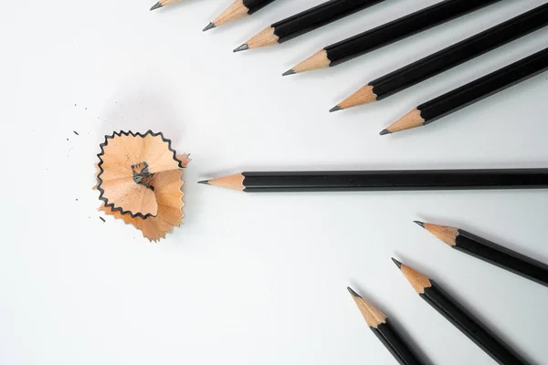 Black pencil and pencil shavings surround by group of black pencil with white background, School concept, Painting and education concepts.