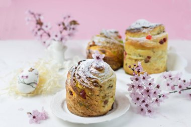 Beyaz bir masada kiraz çiçeklerinin olduğu bir arka planda kek pişirmek. Yan görünüm