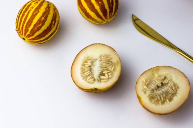 Vietnam kavunu yaklaş. Tam ve kesilmiş gurme minyatür tropikal meyve ve bıçak. Seçici odak