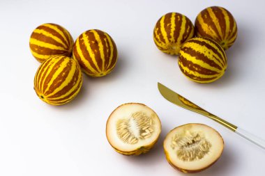 Vietnam kavunu yaklaş. Tam ve kesilmiş gurme minyatür tropikal meyve ve bıçak. Seçici odak