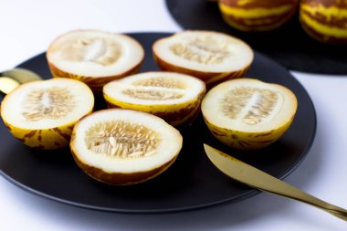 Vietnam kavunu yaklaş. Tam ve kesilmiş gurme minyatür tropikal meyve ve bıçak. Seçici odak