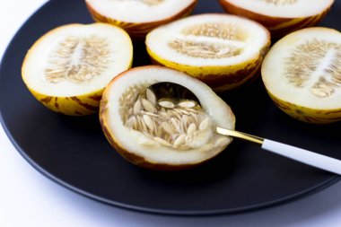 Vietnam kavunu yaklaş. Tam ve kesilmiş gurme minyatür tropikal meyve ve bıçak. Seçici odak