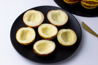 Vietnam kavunu yaklaş. Tam ve kesilmiş gurme minyatür tropikal meyve ve bıçak. Seçici odak