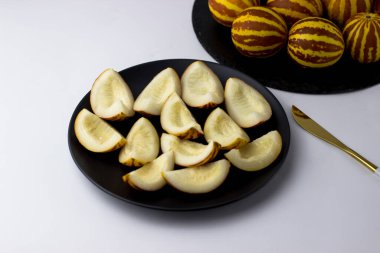 Vietnam kavunu yaklaş. Tam ve kesilmiş gurme minyatür tropikal meyve ve bıçak. Seçici odak