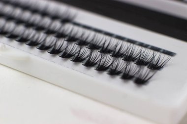 Takma kirpikler yakın plan. Beyaz bir kutuda siyah kirpikler.