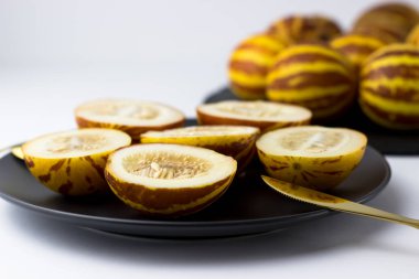 Vietnam kavunu yaklaş. Tam ve kesilmiş gurme minyatür tropikal meyve ve bıçak. Seçici odak