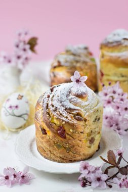Beyaz bir masada kiraz çiçeklerinin olduğu bir arka planda kek pişirmek. Yan görüş. Dikey yönelim