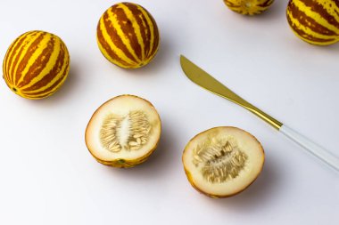 Vietnam kavunu yaklaş. Tam ve kesilmiş gurme minyatür tropikal meyve ve bıçak. Seçici odak