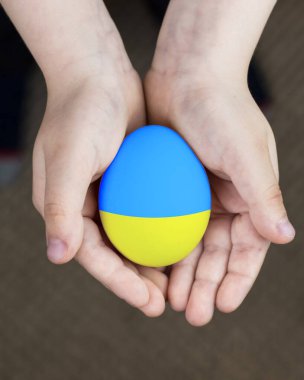 Çocukların ellerinde Ukrayna bayrağının renklerinde Paskalya yumurtası