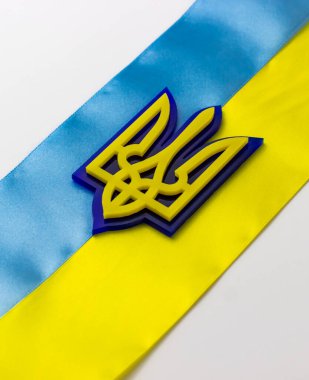 Bayrağın arkasında Ukrayna arması var. Mavi ve sarı çizgili bayrak