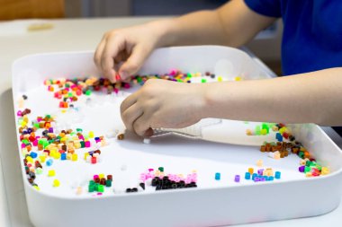 Çocukların elleri termo mozaik oynuyor. Çocuk oyununa yakın çekim