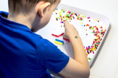 Bir çocuk termo mozaikten Ukrayna bayrağını seriyor. Vatansever Çocuk