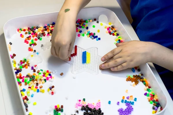 Bir çocuk termo mozaikten Ukrayna bayrağını seriyor. Vatansever Çocuk