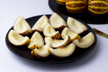 Vietnam kavunu yaklaş. Tam ve kesilmiş gurme minyatür tropikal meyve ve bıçak. Seçici odak