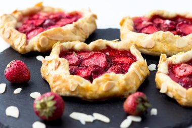 Siyah arka planda çilekli lezzetli mini bisküviler. Porsiyonlu böğürtlen