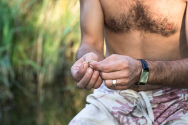 Balıkçılık malzemeleri yapan genç bir adamın elleri.