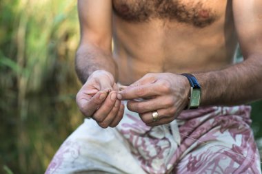 Balıkçılık malzemeleri yapan genç bir adamın elleri.