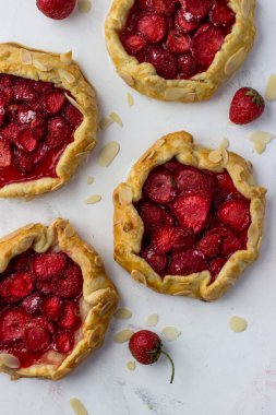 Beyaz arka planda çilekten yapılmış mini bisküviler. Lezzetli mini turtalar. Üst görünüm