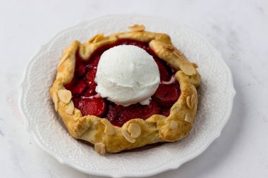 Çilekli mini bisküvi ve bir top dondurma. Beyaz arka planda lezzetli bir çilekli turta.