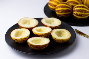 Vietnam kavunu yaklaş. Tam ve kesilmiş gurme minyatür tropikal meyve ve bıçak. Seçici odak