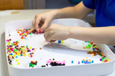 Çocukların elleri termo mozaik oynuyor. Çocuk oyununa yakın çekim