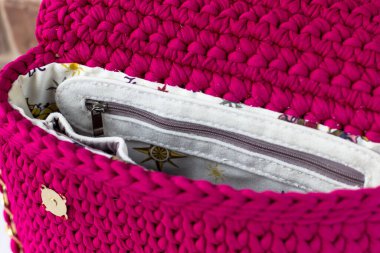 Örgü ipliğinden örülmüş bir çanta. Cepleri dolu. İçerideki çanta görüntüsü