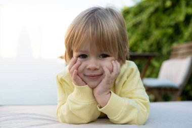 Parkta gülümseyen küçük mutlu çocuğa yaklaş. Parkta beyaz çocuk portresi var..