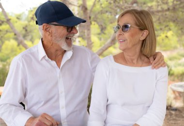 Güneşli bir günde bir parkta gülümseyen mutlu yaşlı çift