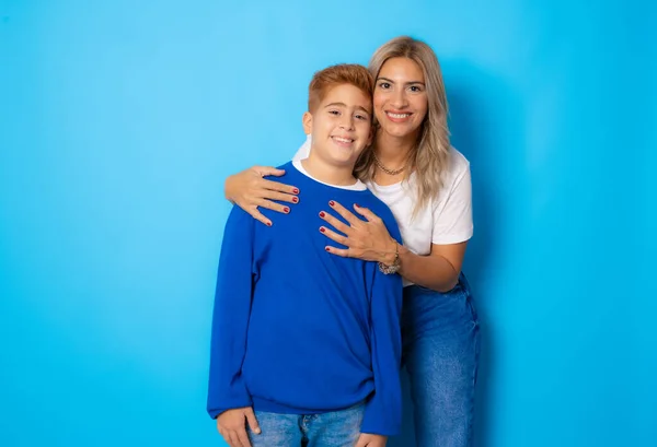 Retrato Jovem Mãe Filho Contra Fundo Azul Olhando Para Câmera — Fotografia de Stock