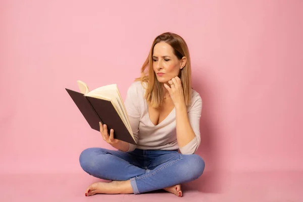 Fiatal Padlón Olvasás Egy Könyvet Elszigetelt Rózsaszín Háttér — Stock Fotó