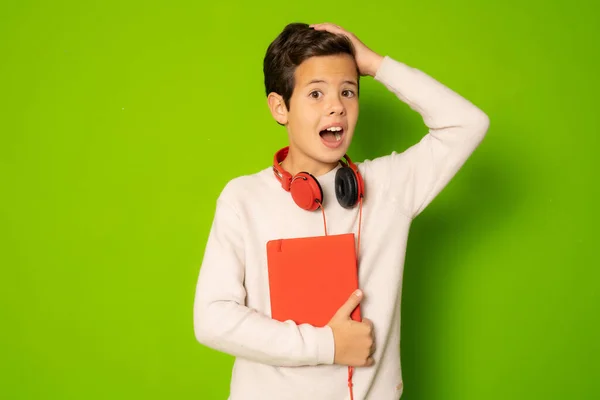 Erstauntes Kind Mit Kopfhörer Das Buch Isoliert Über Grünem Hintergrund — Stockfoto
