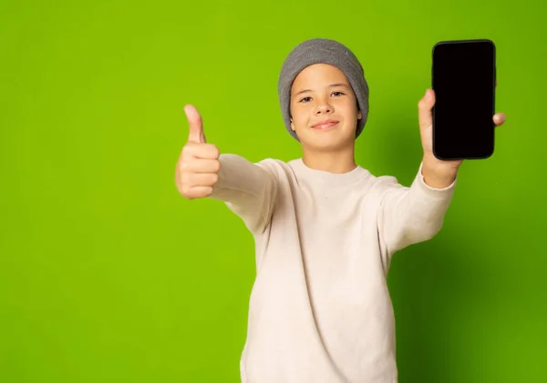 Радостный Мальчик Держит Телефон Большим Пальцем Вверх Изолированы Зеленом Фоне — стоковое фото
